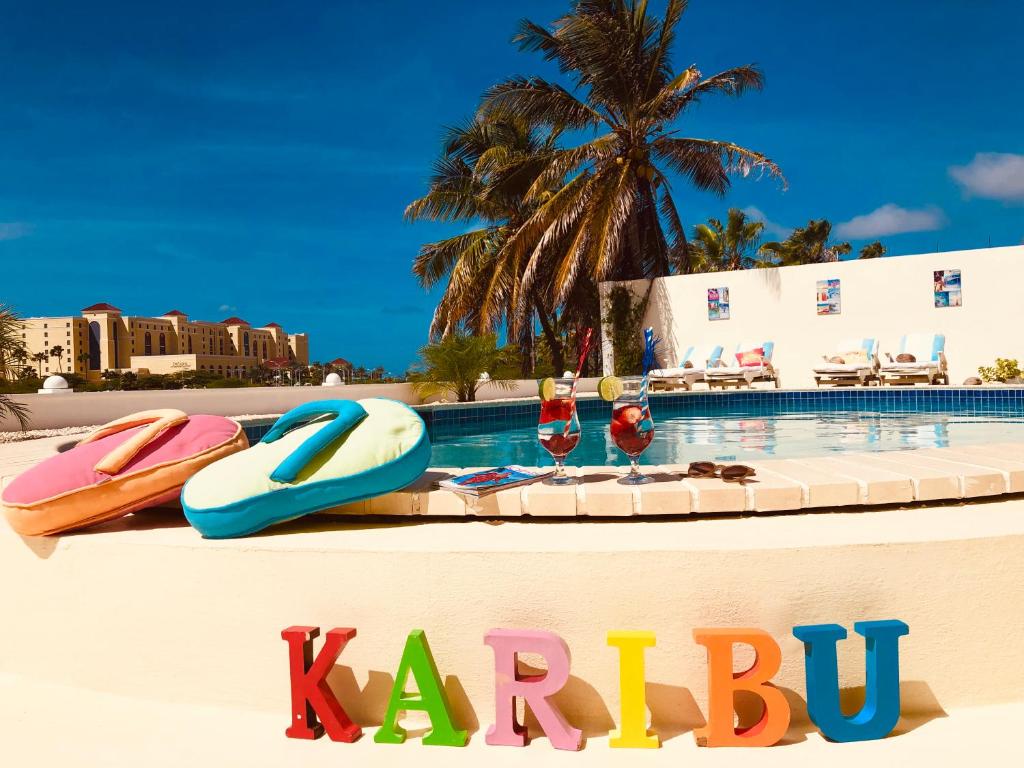 棕榈滩卡里布阿鲁巴精品酒店的游泳池旁的卡布标志