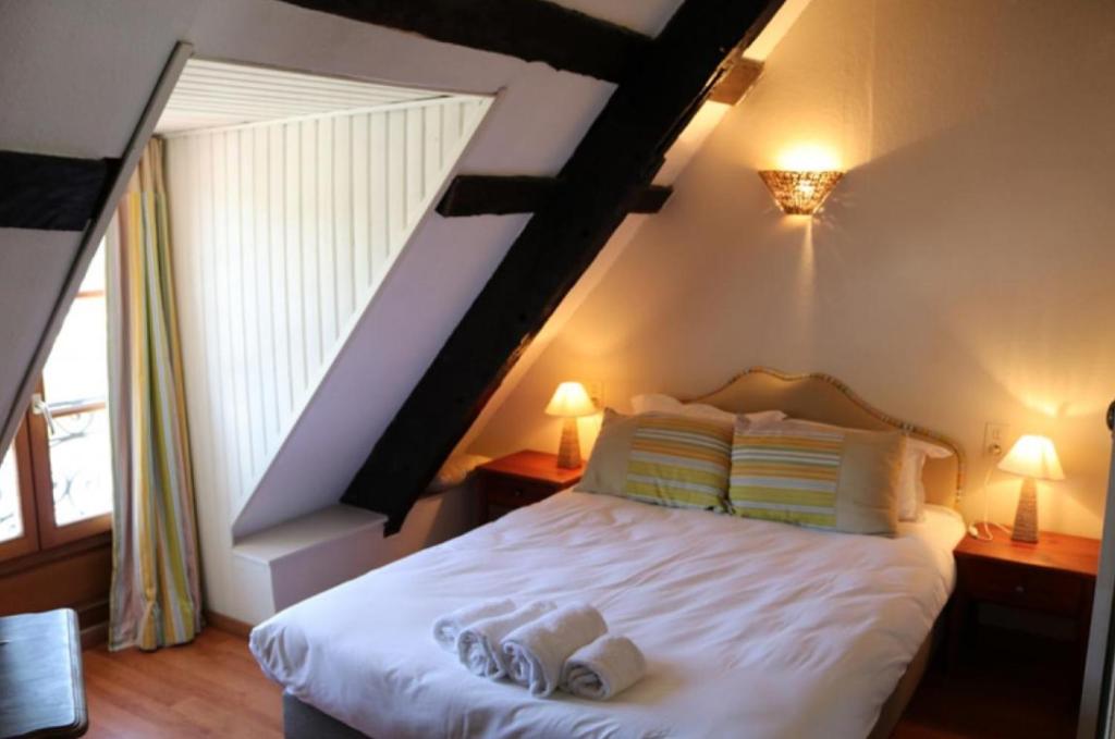 迪南Le Poisson Ivre的一间卧室配有一张床,上面有两条毛巾