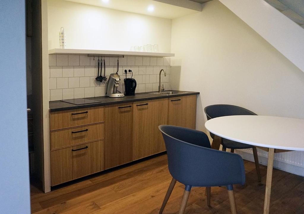 斯哈伦代克Finca Vrij的厨房配有桌子、椅子和桌子