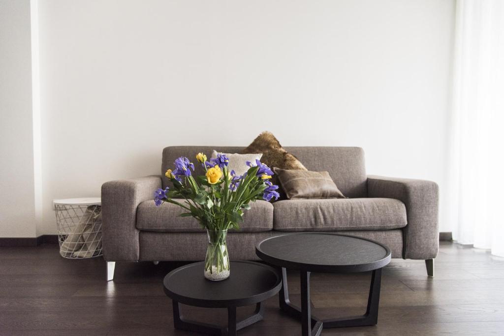 米兰Design & New Center Apartments的客厅配有沙发和鲜花花瓶