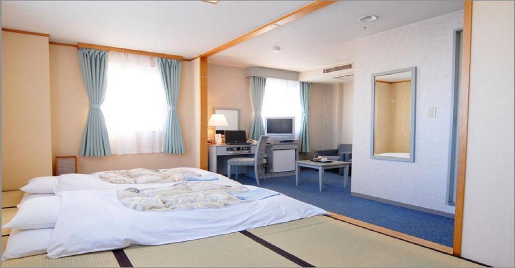 静冈Seagrande Shimizu Station Hotel / Vacation STAY 8211的一间卧室配有一张床和一张带电脑的书桌