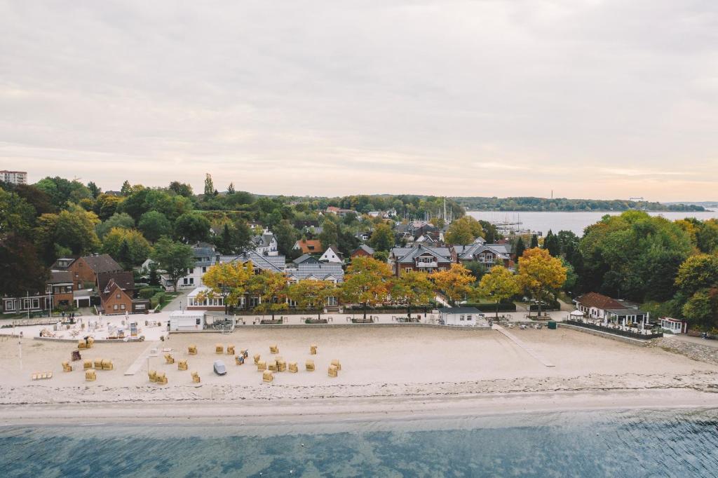 海肯多夫StrandHotel Seeblick, Ostseebad Heikendorf的享有海滩空中美景,提供椅子和公寓