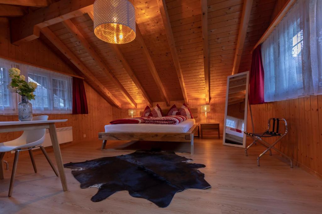 格施泰格维勒Chalet Wäschhüsli near Interlaken, Grindelwald and Lauterbrunnen的一间设有一张床铺的卧室,位于一个拥有木制天花板的房间