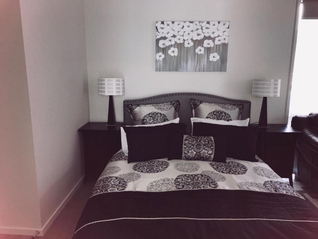 RiverheadModern Self Contained Apartment in Riverhead的卧室配有带枕头的黑白床。