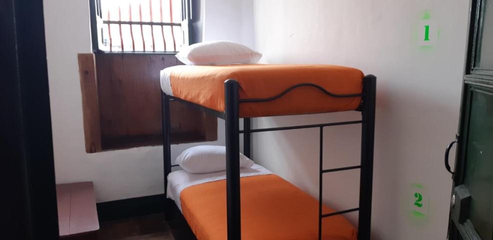 波哥大Cedron Hostel的配有橙色座椅的客房内的双层床