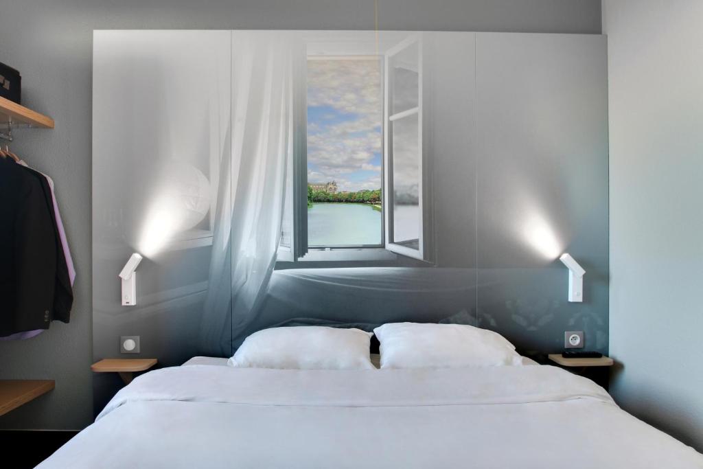 香槟沙隆B&B HOTEL Châlons-en-Champagne的卧室设有两张床,带窗户