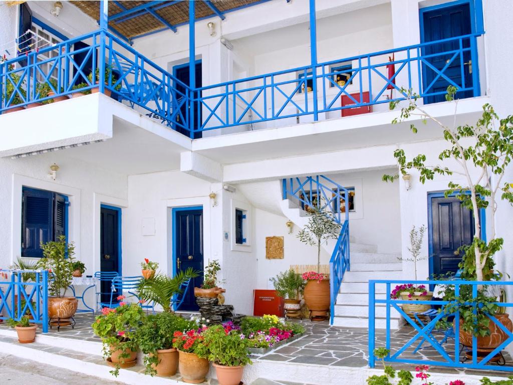 爱琴娜岛Electra的一座有蓝色门和盆栽植物的建筑