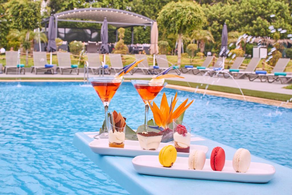 阿加迪尔Mabrouk Hotel and Suites- Adult only的游泳池畔的桌子上放着两杯饮料