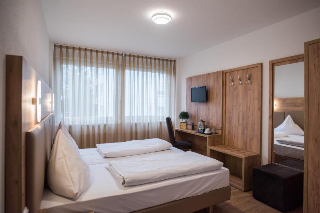 埃根斯泰因-列奥波德港Hotel Leo的酒店客房,设有两张床和镜子