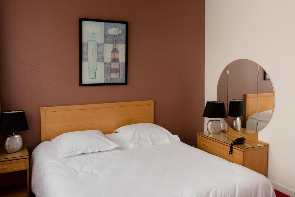 图尔Cit'Hotel Criden的卧室配有白色的床和镜子