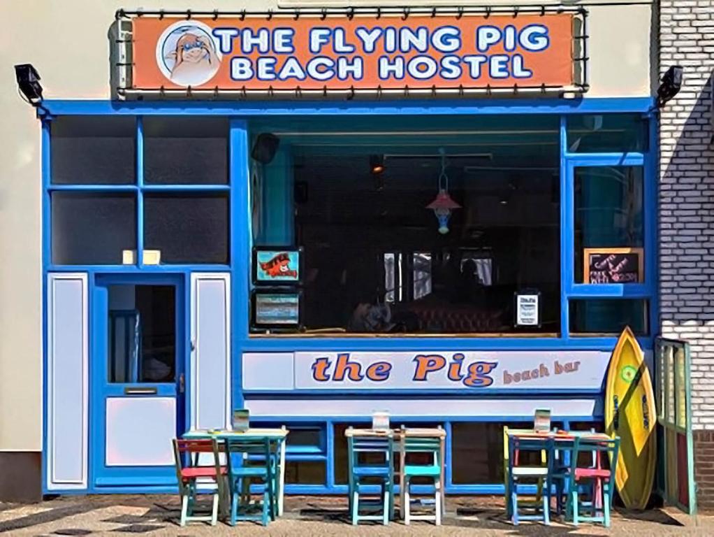 海滨诺德韦克The Flying Pig Beach Hostel, ages 18 - 40的前面的海滩房屋配有桌椅