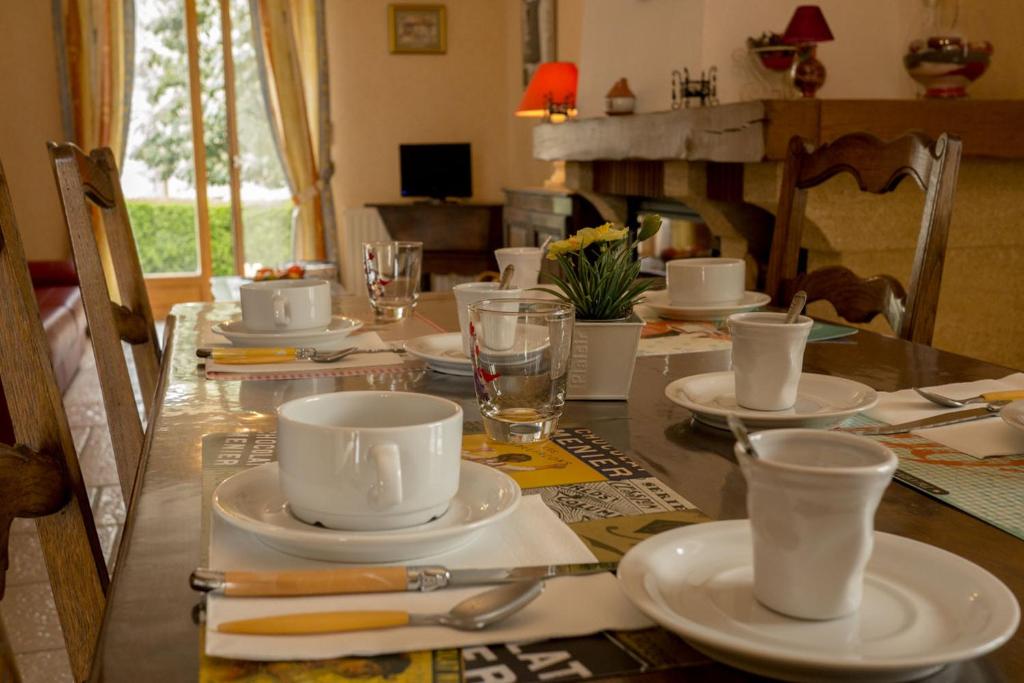 La Rochepot莱斯罗查德斯住宿加早餐旅馆的一张桌子上放着白杯和碟子