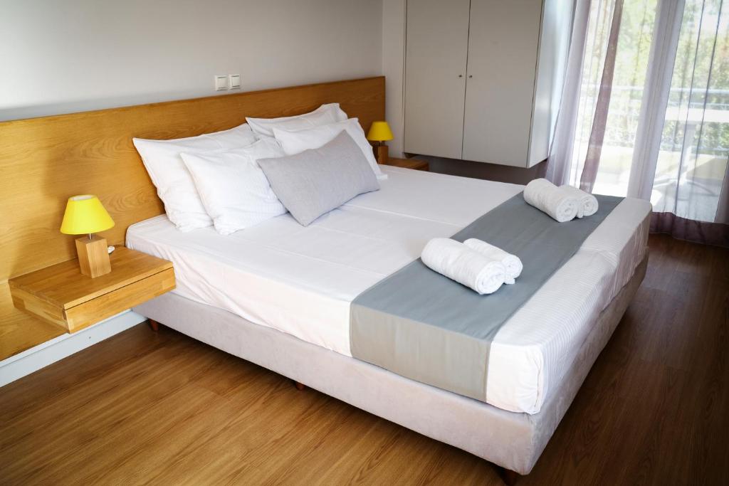 米蒂利尼萨福公寓的卧室配有一张带2条毛巾的大型白色床