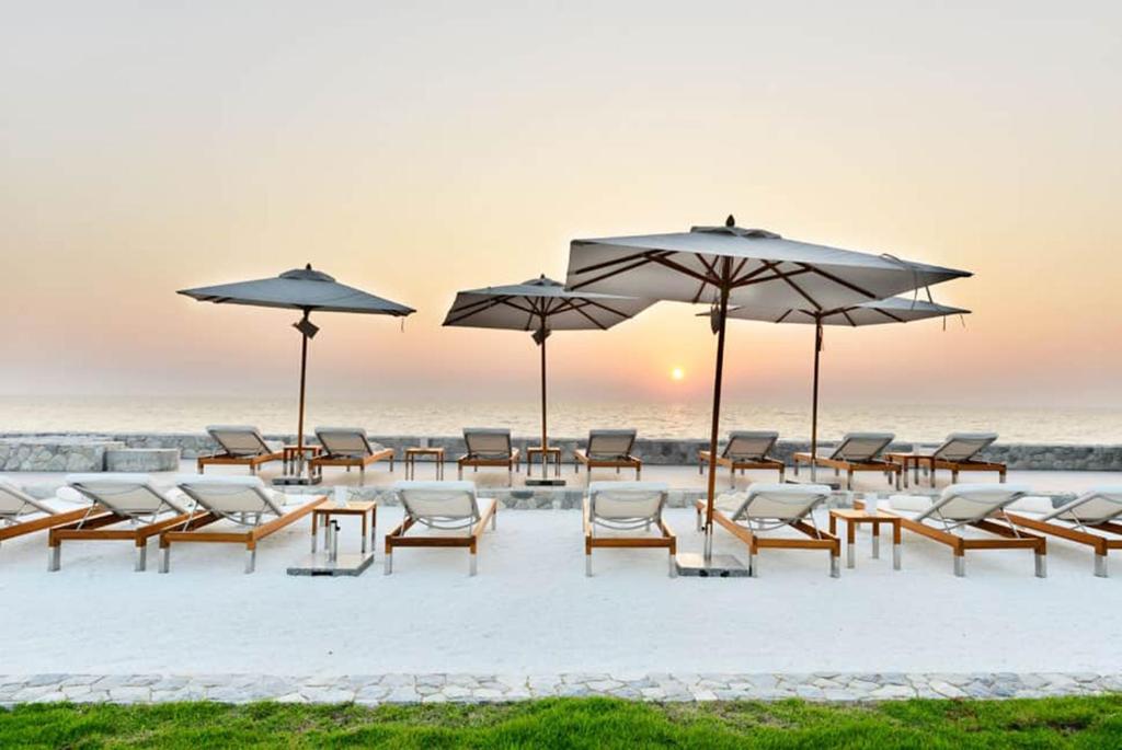纳仲天Veranda Residence Pattaya x Sea & Sky View的海滩上的一组椅子和遮阳伞