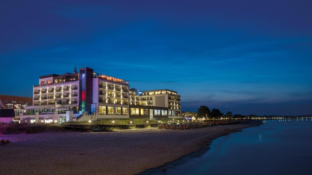 沙博伊茨海湾酒店的一座晚上坐在海滩上的建筑