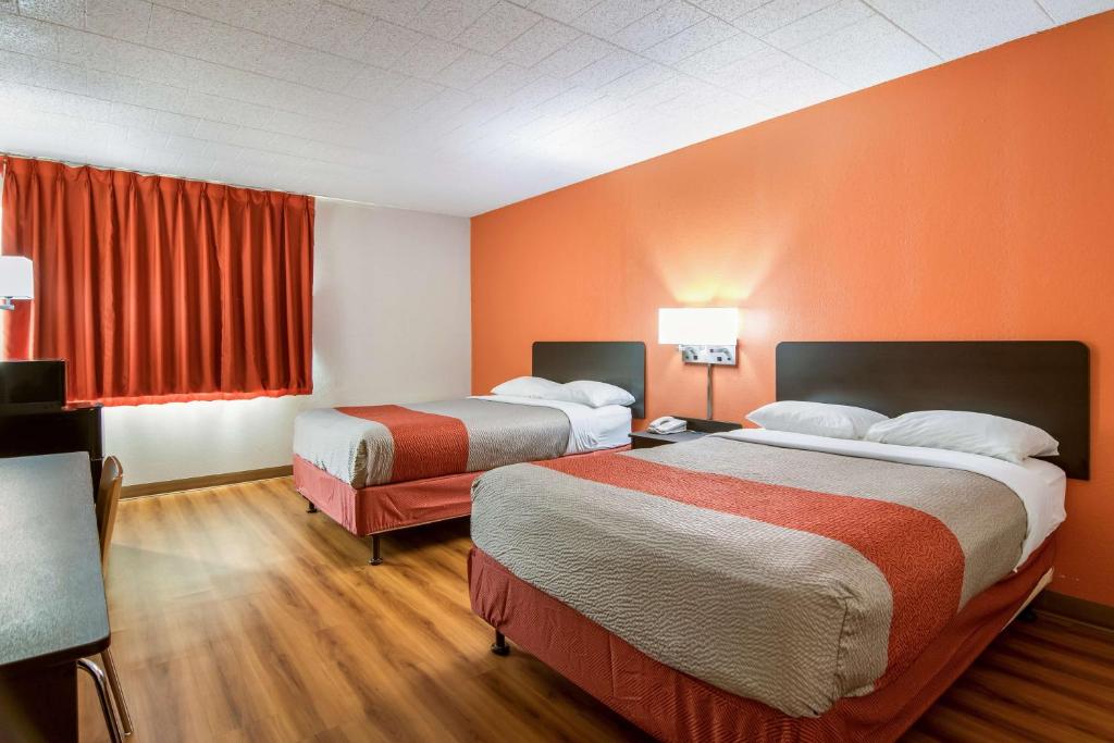 新斯坦顿新斯坦顿6号汽车旅馆的橙色墙壁的酒店客房内的两张床