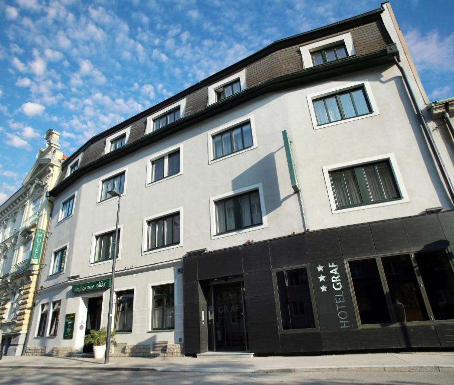 圣珀尔滕格拉夫旅馆酒店的一条城市街道上的白色大建筑