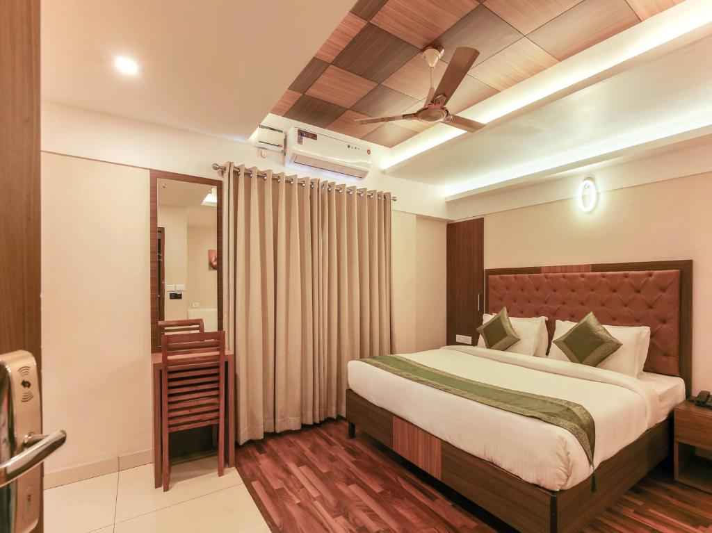 特里凡得琅Treebo Trend Goodland Residency的一间卧室配有一张床和吊扇
