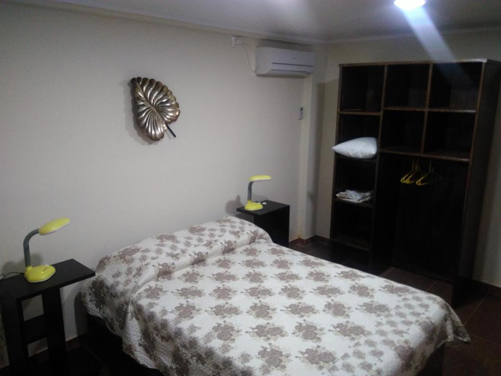 伊瓜苏港ZUHAUSE的卧室配有一张床,墙上挂着一个钟