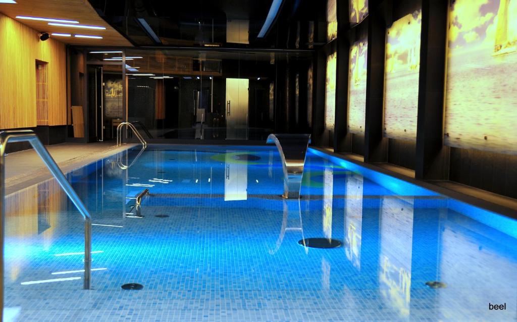 波兹南帆船酒店、餐厅及Spa温泉的蓝色建筑中的游泳池