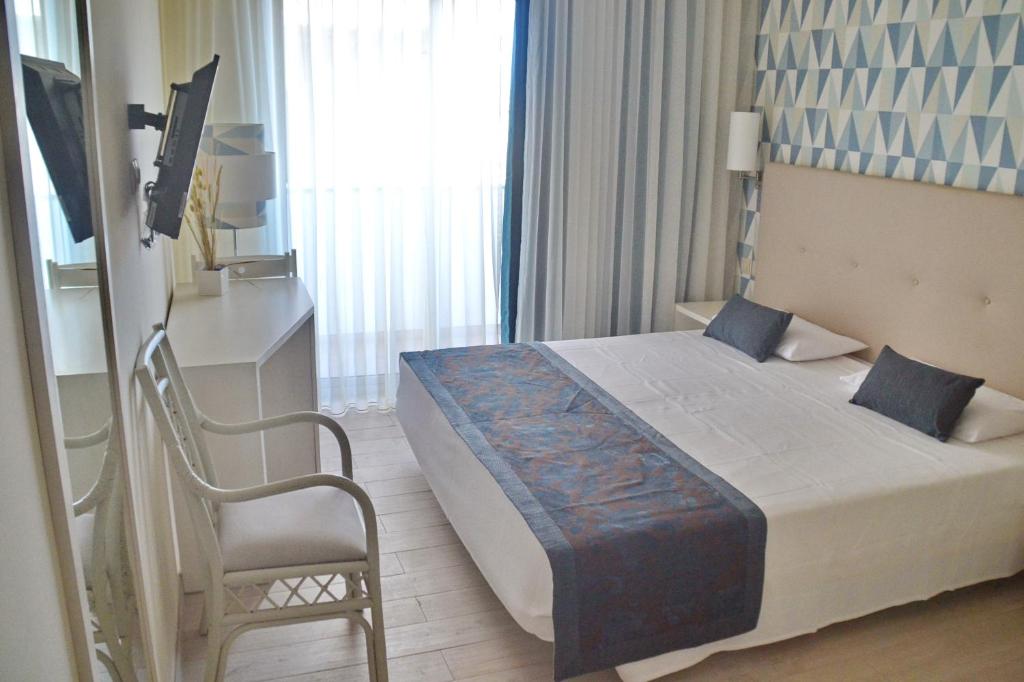 圣玛丽亚Ouril Hotel Julia的一间卧室,卧室内配有一张床和一把椅子
