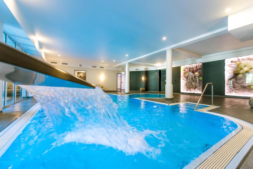 科赫姆莫斯罗曼蒂克凯斯勒迈耶酒店的大楼内一个带水滑梯的大型游泳池