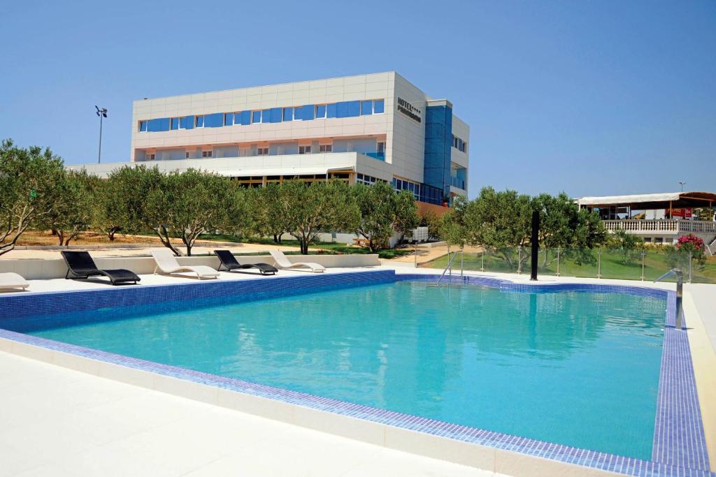 希贝尼克全景酒店的一座带躺椅的大型游泳池和一座建筑