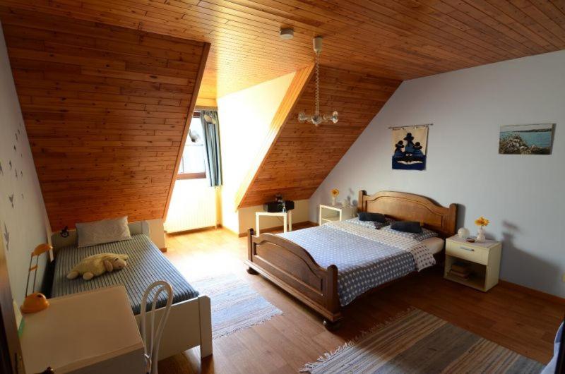 赫林贝亨B&B Vanderstraeten-Bryxis的一间卧室设有两张床和木制天花板