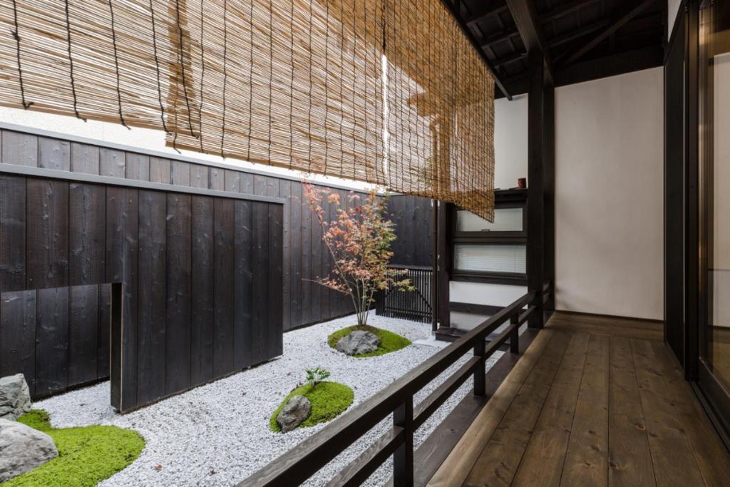 京都京町家一棟貸しKyoto Machiya Stay En的花园位于带围栏的客房中间