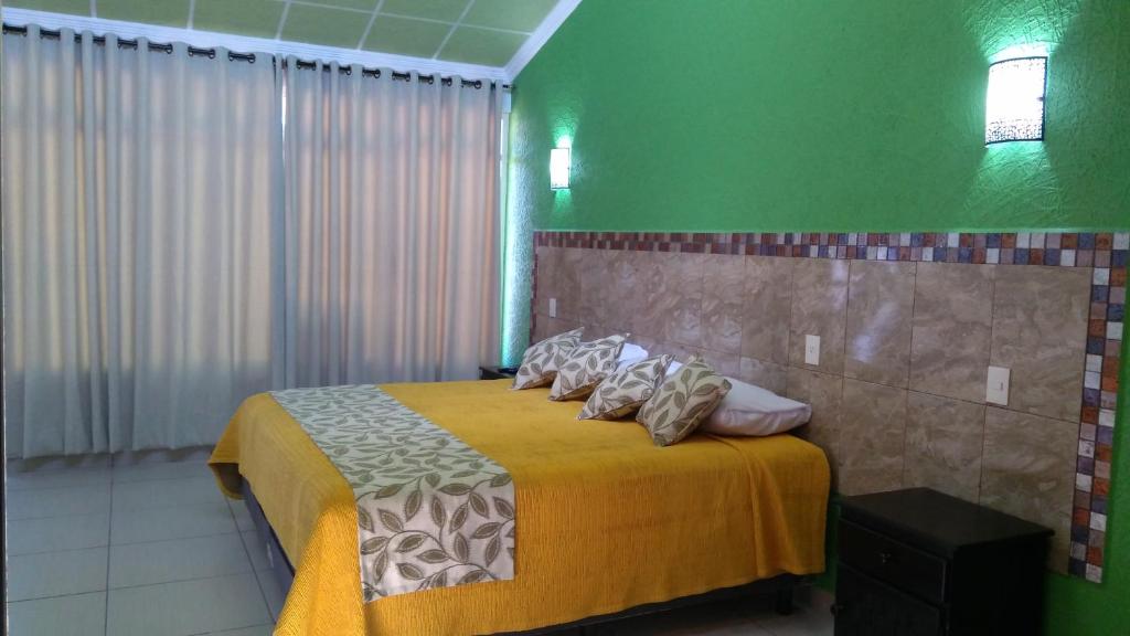 San Martín de las PirámidesVilla Victoria Pirámides的一间卧室配有一张带黄色毯子和枕头的床。