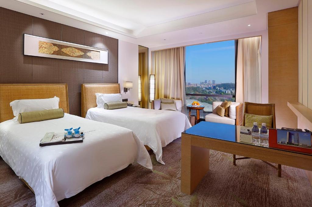 东莞东莞康帝国际酒店的酒店客房配有两张床和一张书桌