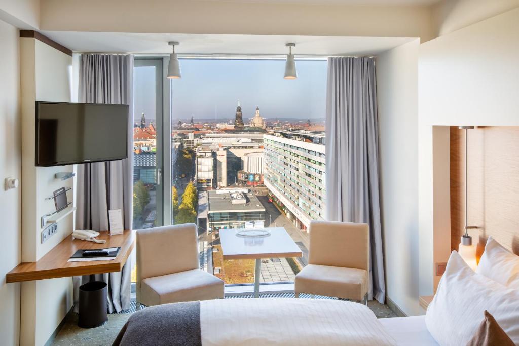 德累斯顿普尔曼·德瑞斯登·纽沃酒店的酒店客房享有城市美景,配有一张床。