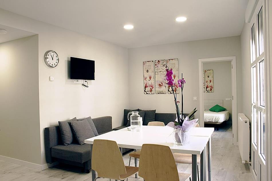 洛格罗尼奥Apartamentos Logroño Centro的客厅配有白色的桌子和椅子