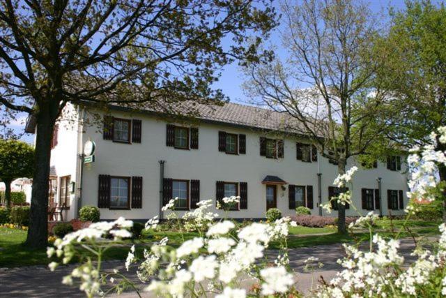 黑耶拉特克罗采酒店的前面有树木和鲜花的白色房子