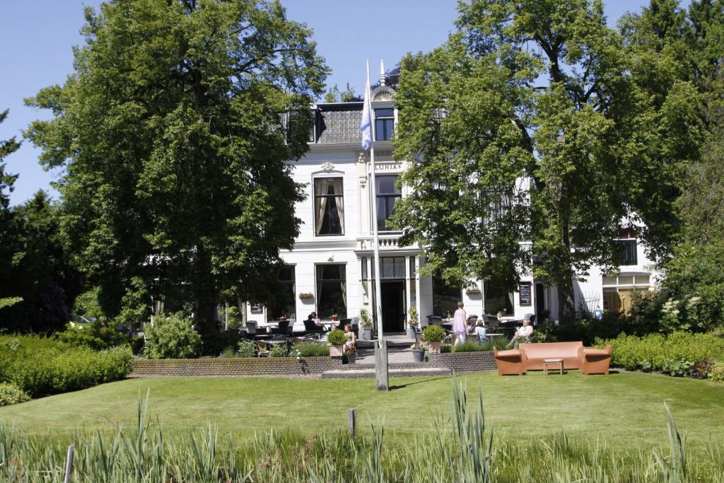 奥尔德伯科普Hotel Restaurant Lunia的前面有草坪的白色房子