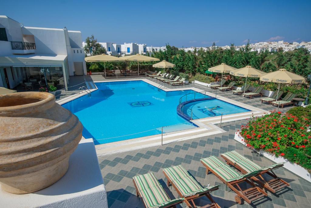 纳克索乔拉艾斯特纳克索斯酒店的度假酒店的游泳池配有躺椅和遮阳伞