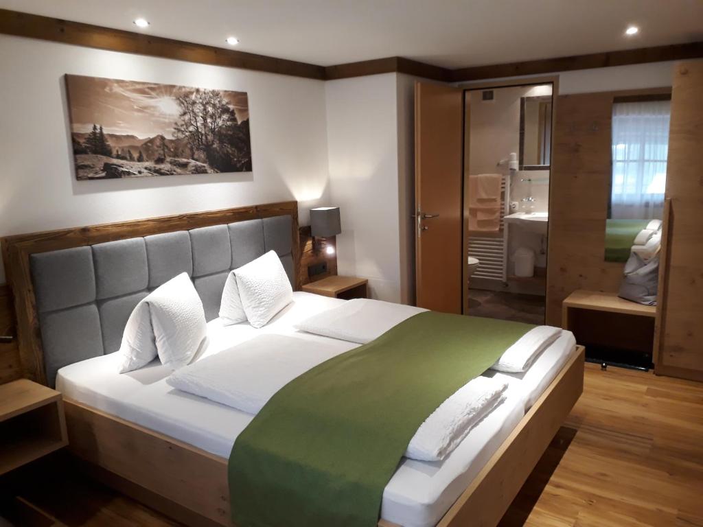 明施特尔Denggnhof的一间卧室配有一张带绿毯的大床