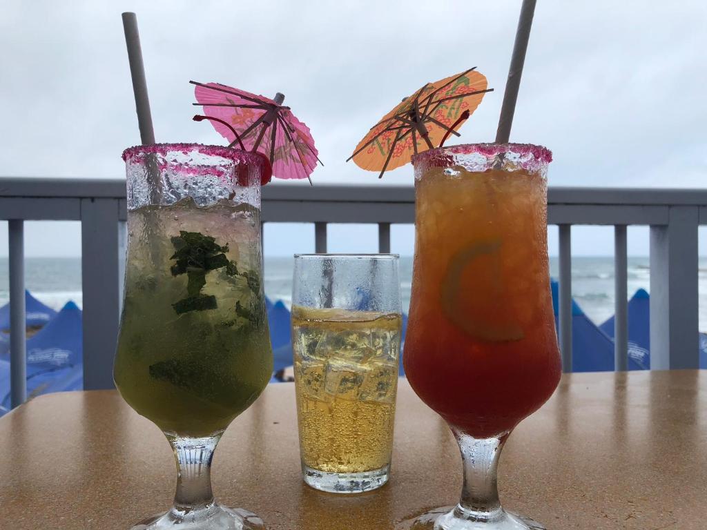莫塞尔湾Sea-View Nautica @ Mossel Bay的坐在阳台上的桌子上,喝了三杯饮料