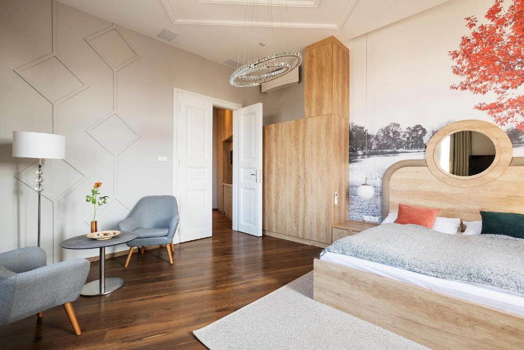 布达佩斯Lakeside Budapest Residences的一间卧室配有一张床、一把椅子和一张桌子