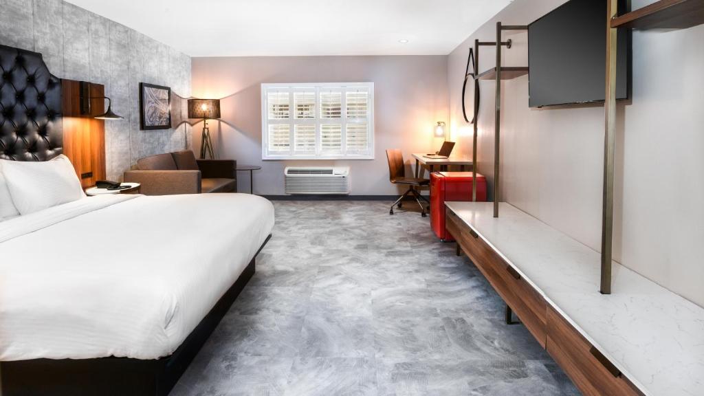洛杉矶Hollywood Inn Suites Hotel的配有一张床和一张书桌的酒店客房