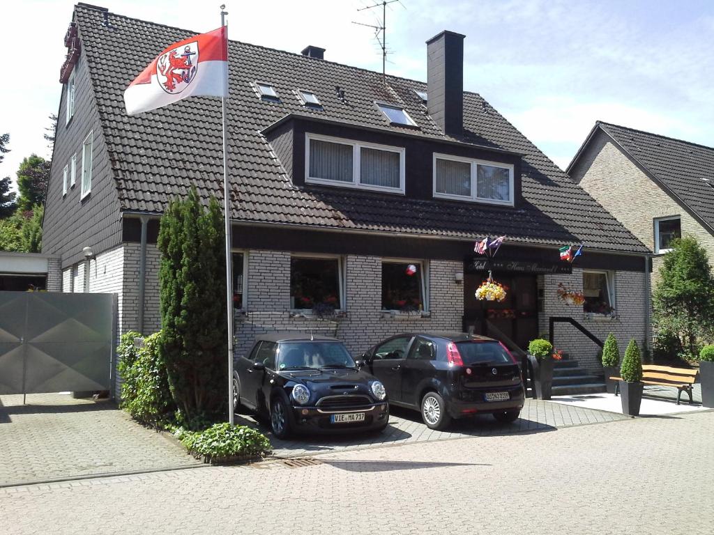 杜塞尔多夫马拉德酒店的两辆汽车停在一座有旗帜的房子前