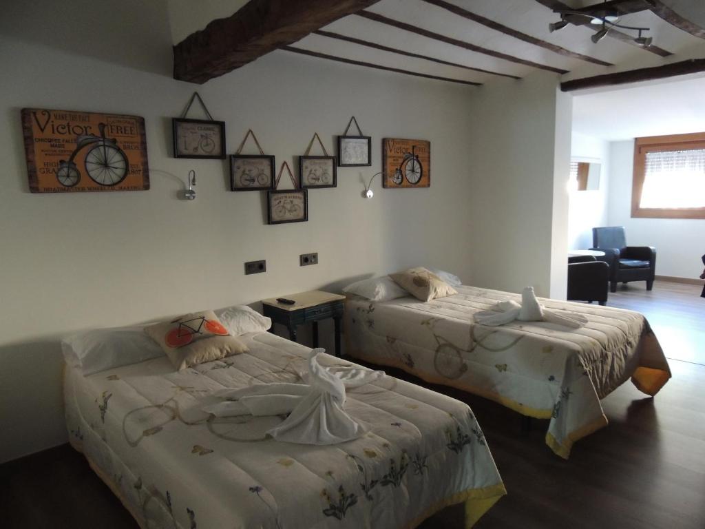 贝洛拉多Hotel La Huella Del Camino的一间卧室配有两张床、一张桌子和一把椅子
