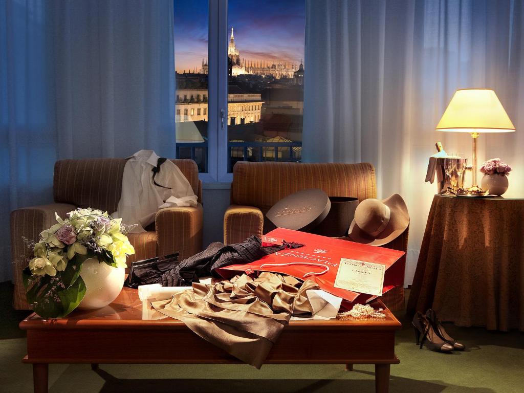 米兰卡沃尔酒店的客厅配有带衣服的桌子