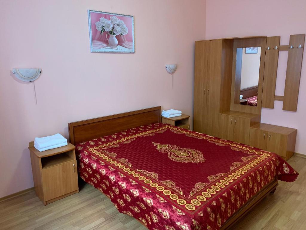 基辅Inn on Zhytomyrska的一间卧室配有一张带红色床罩和镜子的床
