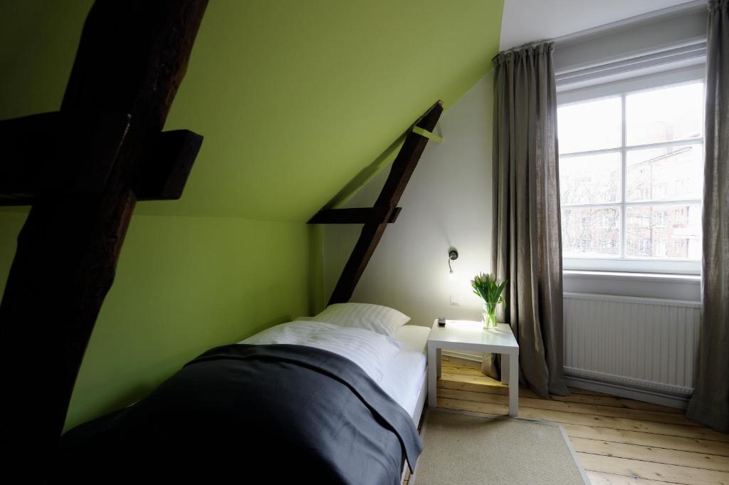 汉堡Hotel KUHBERG Hamburg的绿色卧室设有床和窗户