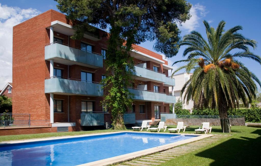 卡斯特尔德费尔斯SG科斯塔巴塞罗那公寓式酒店的公寓大楼前方设有游泳池