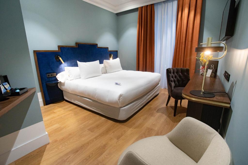 马德里Soho Boutique Congreso的酒店客房配有一张床、一张桌子和一把椅子。