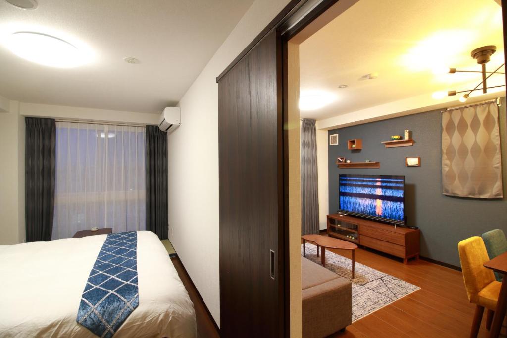 金泽W&M House的酒店客房,配有床和电视