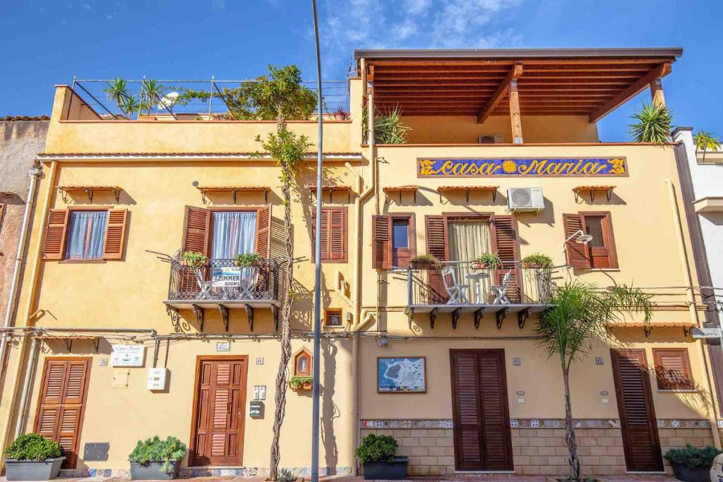 圣夫拉维亚Solemar Sicilia - Casa Maria的黄色的建筑,上面有标志