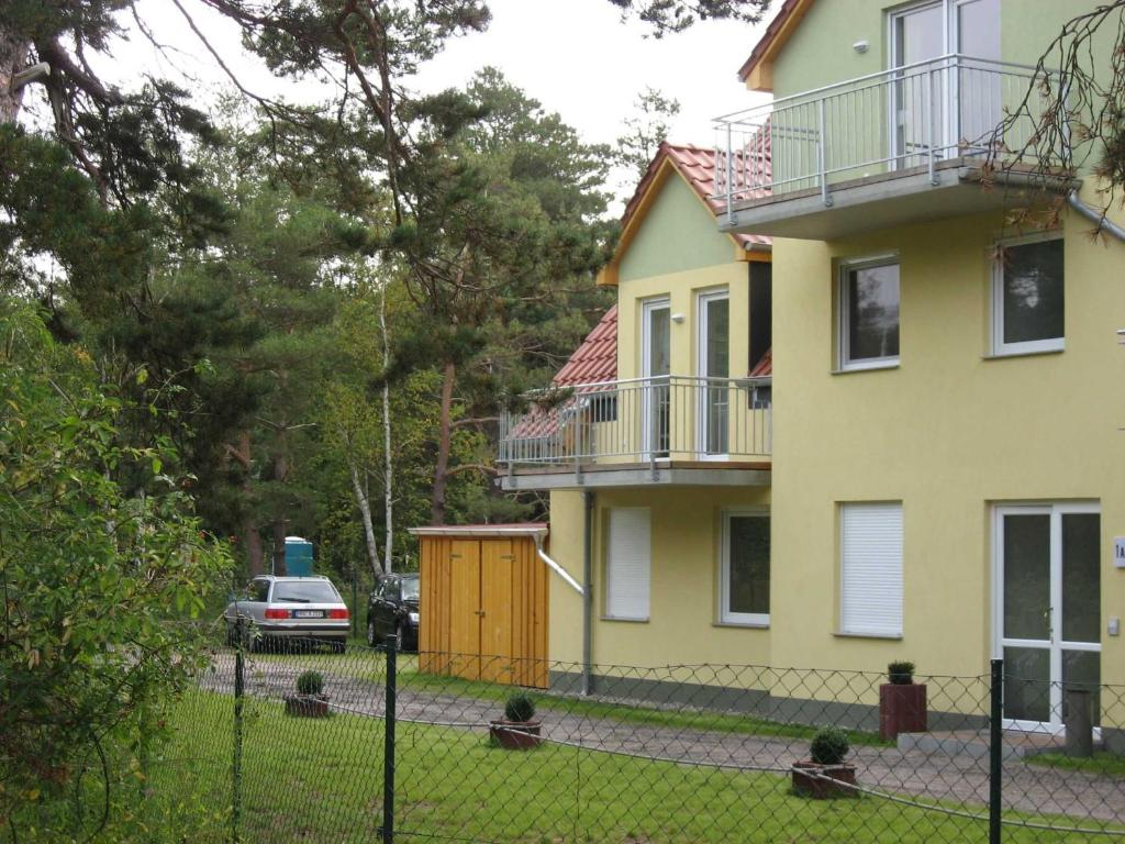 奥茨塞巴德·迪尔哈根SEESTERN App Nr 12 max 6 Pers的前面有栅栏的黄色房子